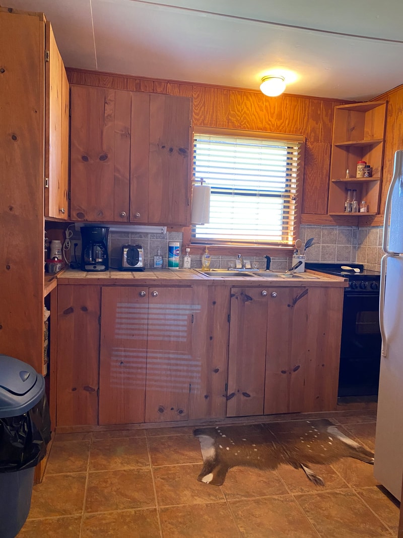 Wood-paneled kitchen with sink and appliances